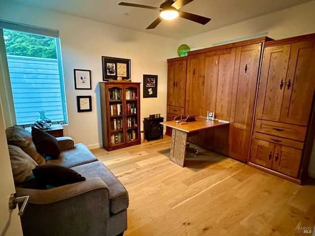 home office with light hardwood / wood-style flooring and ceiling fan