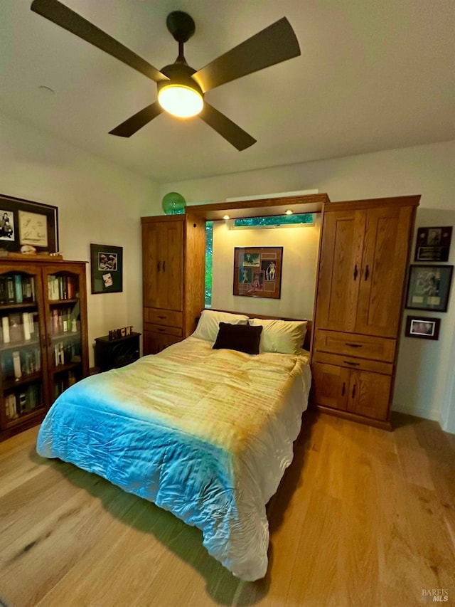 bedroom with ceiling fan and light hardwood / wood-style flooring