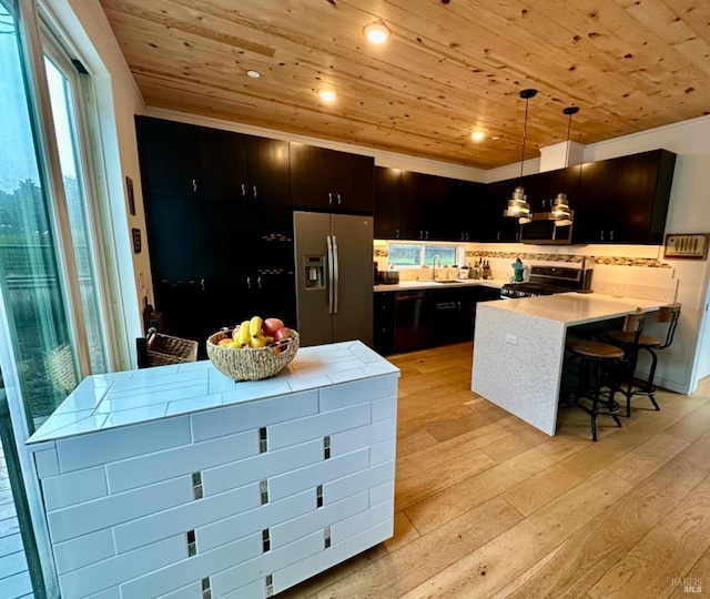 kitchen featuring decorative light fixtures, stainless steel appliances, wooden ceiling, and light wood-type flooring