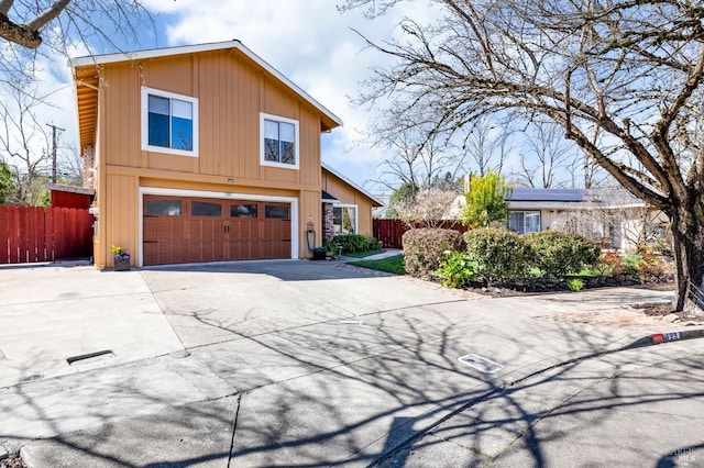 view of front of property featuring a garage, driveway, and fence