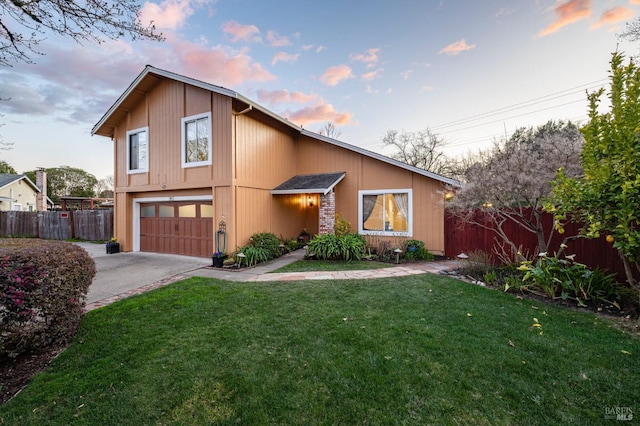 view of front facade with a garage, driveway, a yard, and fence