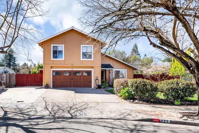 view of front of house featuring an attached garage, fence, and driveway