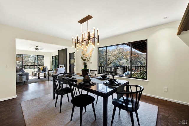 dining room with baseboards and ceiling fan with notable chandelier