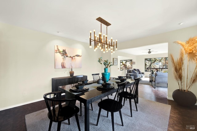 dining room with ceiling fan with notable chandelier and baseboards