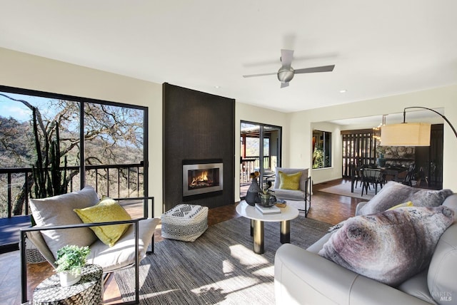 living room with a fireplace and ceiling fan