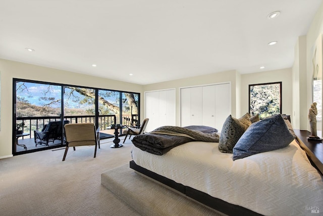 carpeted bedroom featuring multiple windows, recessed lighting, two closets, and access to exterior