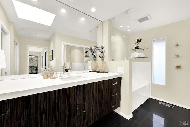 bathroom featuring recessed lighting, visible vents, vanity, a skylight, and baseboards