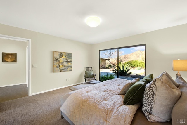 carpeted bedroom featuring baseboards and access to exterior