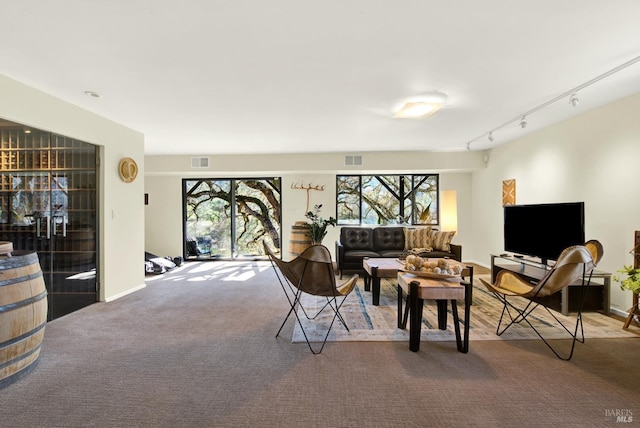carpeted living area featuring baseboards and visible vents