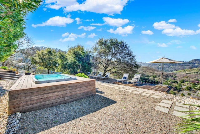 view of yard featuring a jacuzzi and a mountain view