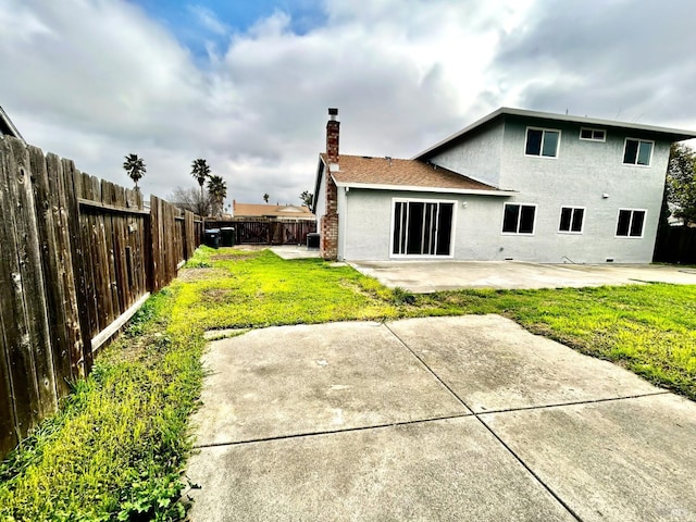 back of property with a patio area and a lawn