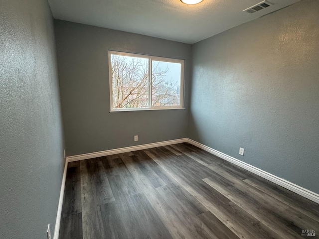 empty room with dark hardwood / wood-style flooring