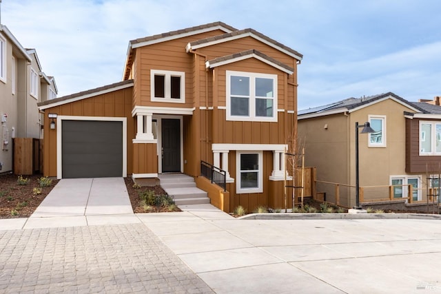 view of front of property featuring board and batten siding, driveway, and an attached garage