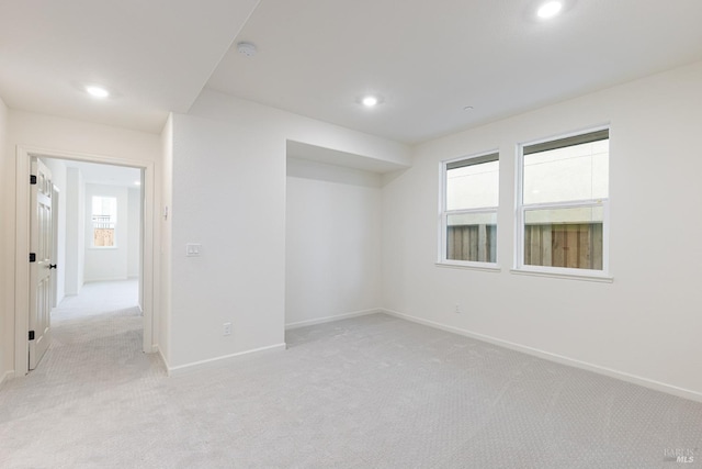 empty room with recessed lighting, light colored carpet, and baseboards