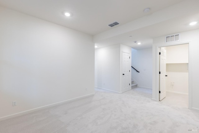 interior space featuring light carpet, baseboards, stairs, and visible vents