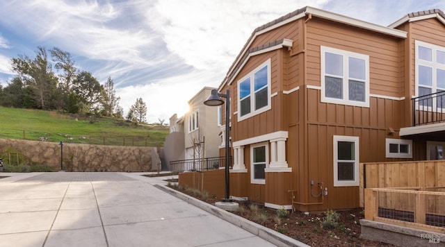 view of side of home with fence and board and batten siding