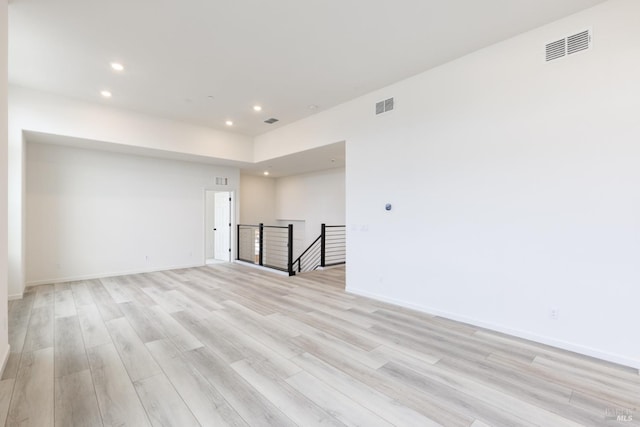 empty room featuring light wood-style flooring, recessed lighting, visible vents, and baseboards