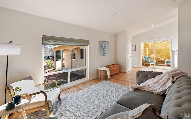 living room with lofted ceiling and light hardwood / wood-style flooring