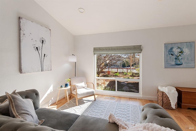 living room with vaulted ceiling and light hardwood / wood-style flooring