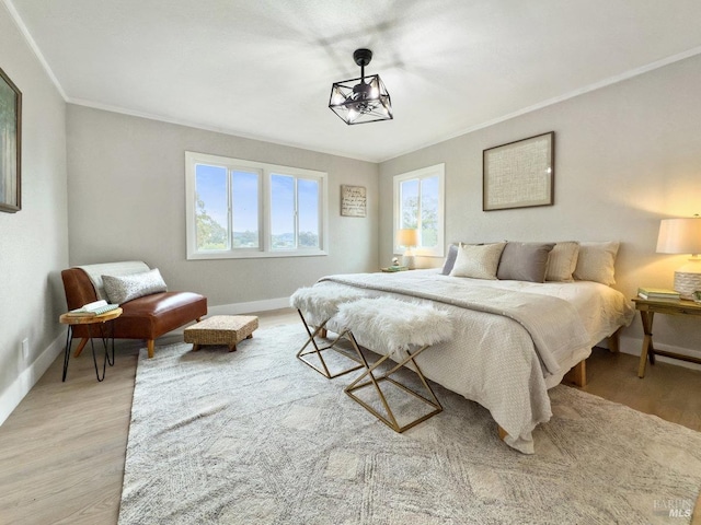 bedroom with baseboards, light wood-style flooring, and crown molding