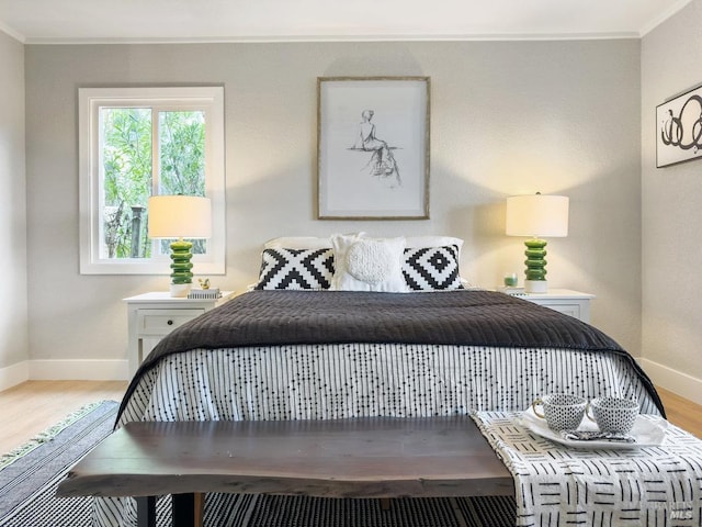 bedroom with baseboards, light wood-style floors, and crown molding