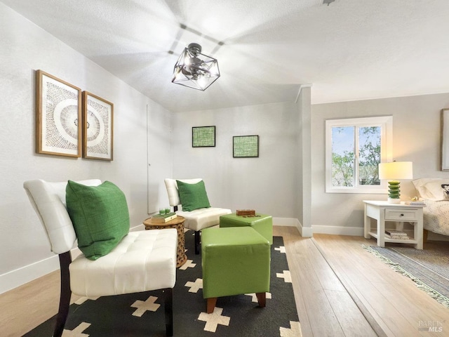 living area with baseboards and wood finished floors