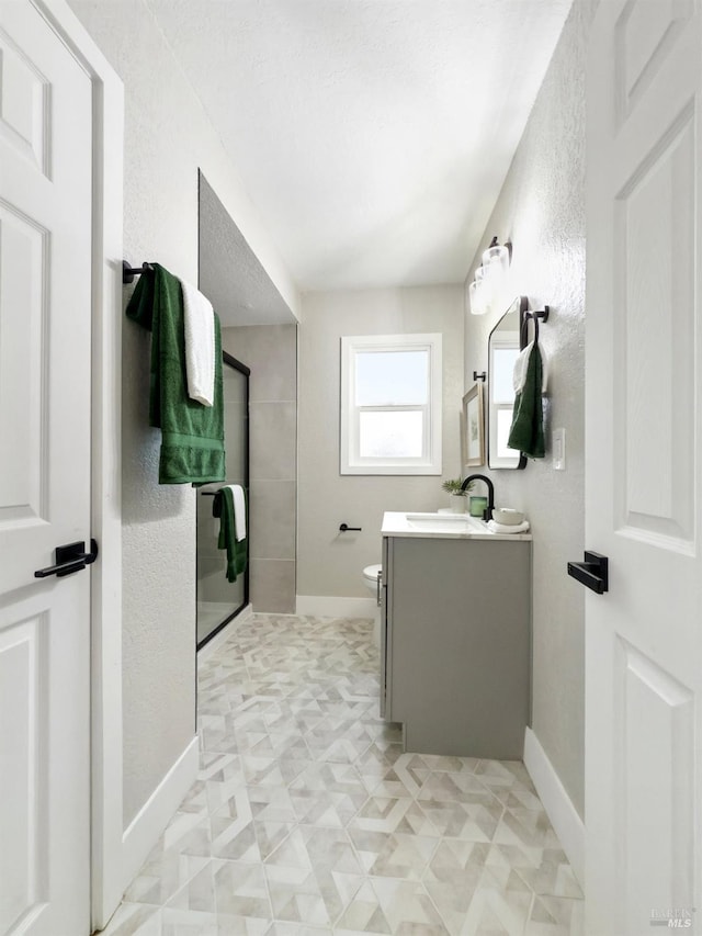 bathroom with baseboards, toilet, and vanity