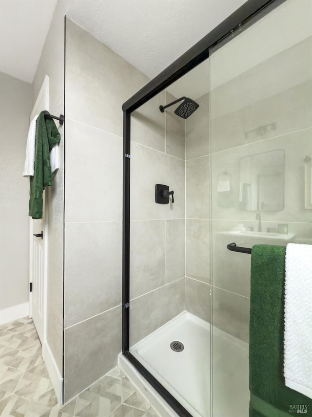 bathroom featuring a shower with shower door