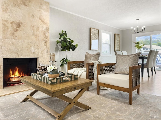 sitting room with crown molding, a fireplace, and an inviting chandelier