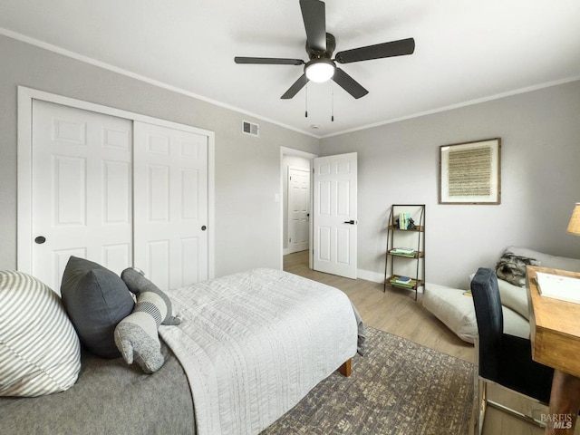 bedroom with hardwood / wood-style floors, crown molding, a closet, and ceiling fan