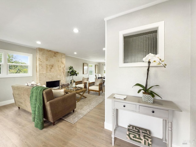 living area featuring a fireplace, recessed lighting, light wood-type flooring, and plenty of natural light