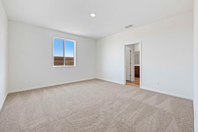 unfurnished room featuring light carpet, visible vents, and baseboards