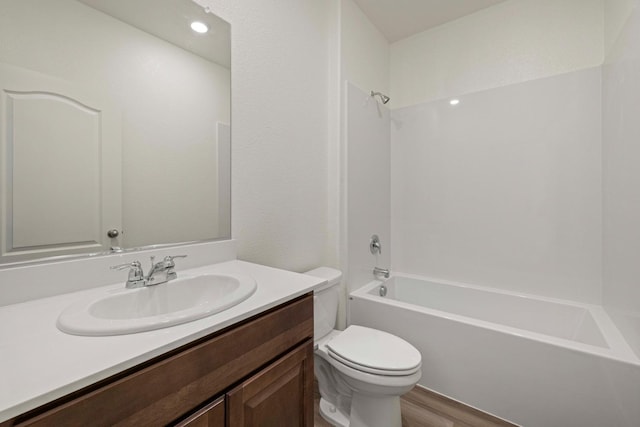 full bathroom featuring wood finished floors, tub / shower combination, vanity, and toilet