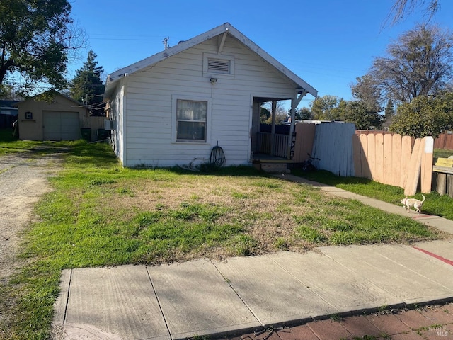 view of front of property with a garage, an outbuilding, and a front lawn