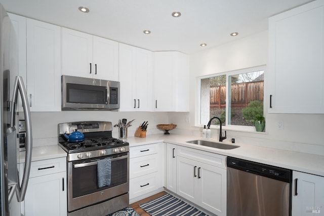 kitchen featuring appliances with stainless steel finishes, sink, and white cabinets