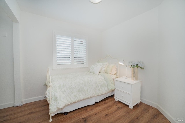 bedroom with dark hardwood / wood-style floors