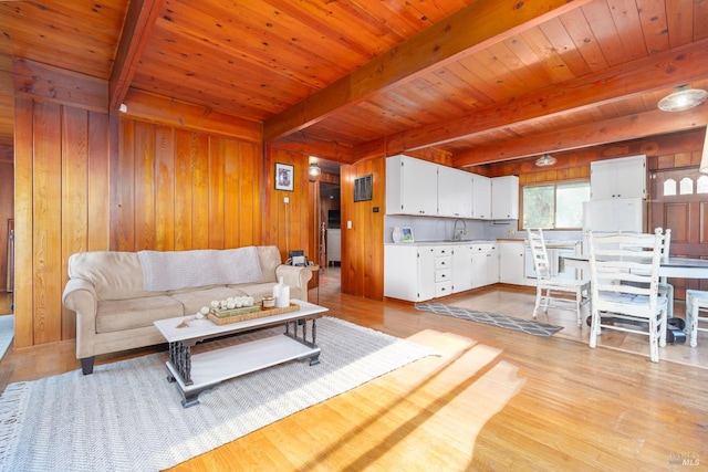 living room with sink, wooden walls, light hardwood / wood-style floors, and wooden ceiling