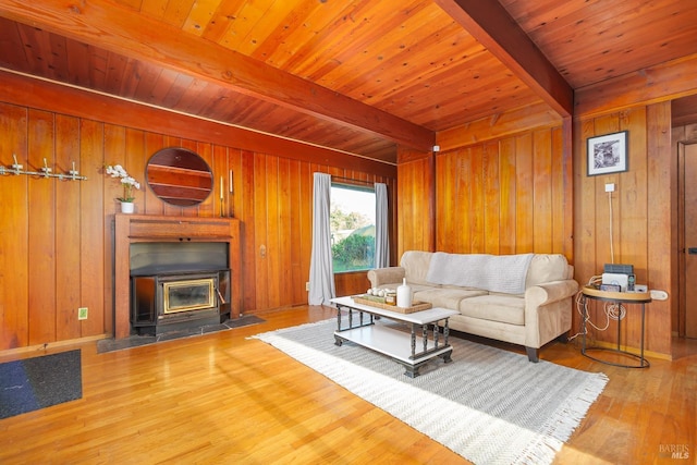 living room with beamed ceiling, wooden walls, and hardwood / wood-style flooring