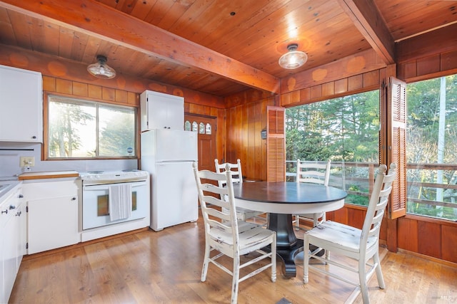 dining space featuring light hardwood / wood-style flooring, wood ceiling, beam ceiling, and wooden walls