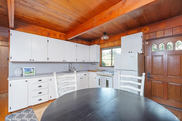 kitchen featuring white appliances, beam ceiling, sink, and white cabinets