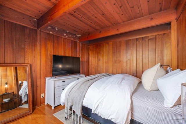 bedroom with beamed ceiling, light wood-type flooring, wooden ceiling, and wooden walls