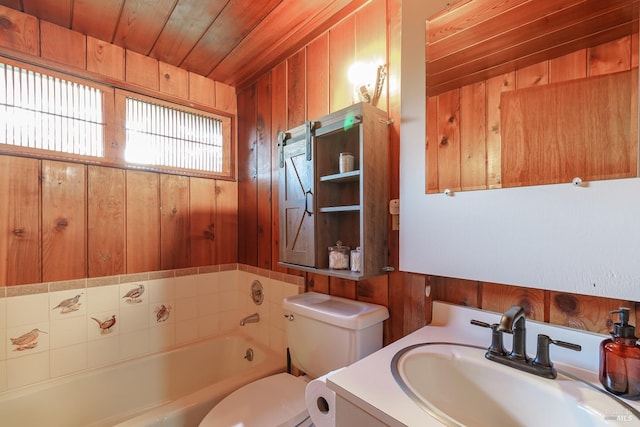 bathroom with wooden walls, vanity, toilet, a bath, and wooden ceiling