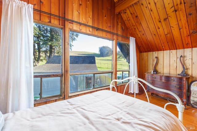 bedroom with multiple windows, wooden walls, lofted ceiling with beams, and wooden ceiling