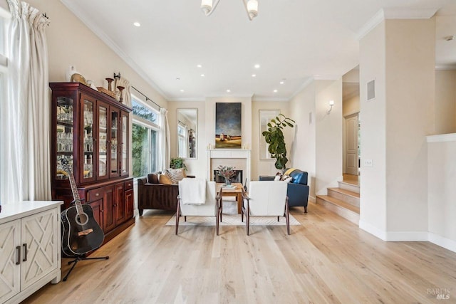 sitting room featuring crown molding and light hardwood / wood-style floors