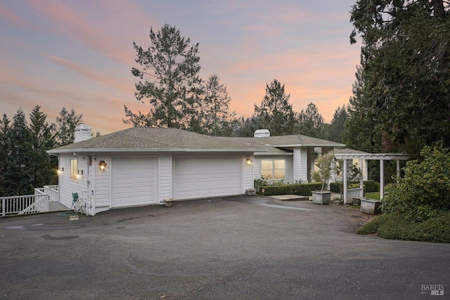 view of front facade featuring a garage and a pergola