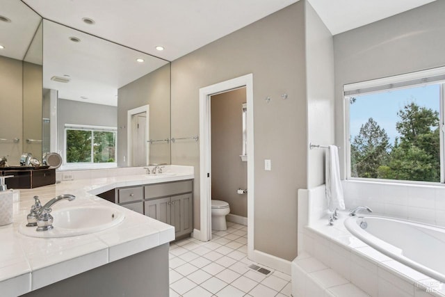 bathroom featuring vanity, tiled bath, tile patterned floors, and toilet