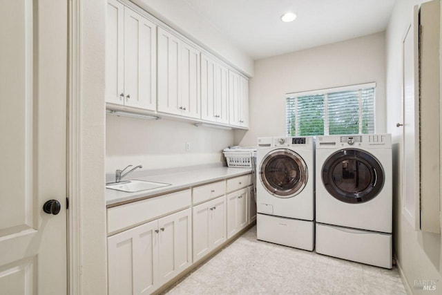 washroom featuring cabinets, sink, and independent washer and dryer