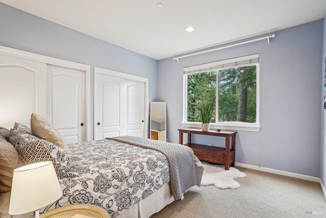 carpeted bedroom featuring two closets