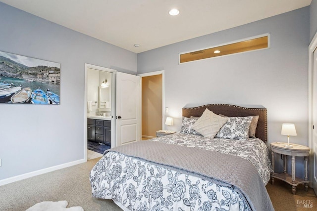 bedroom with ensuite bath and carpet