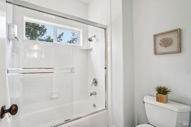 bathroom featuring bath / shower combo with glass door and toilet